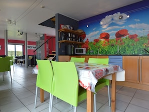 A restaurant with a mural of red flowers, green chairs, and a wooden table. - Sourbrodt Villa With Pool (Waimes)