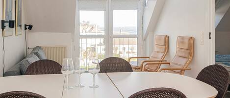 A dining area with a table, chairs, and three wine glasses.