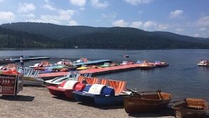 A lakeside dock with various boats and a signboard. - Appealing Apartment in Lenzkirch (Lenzkirch)