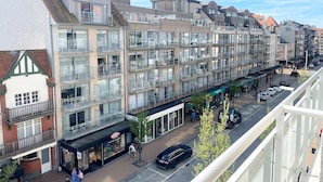 A row of modern apartment buildings with balconies, a street with cars, and a pedestrian walkway. - Apartment in Nieuwpoort With sea Views (Nieuwpoort)