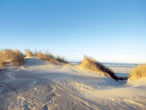 A sandy beach with dunes and a clear sky. - Dunenhuus Ost Modern Retreat (Juist)