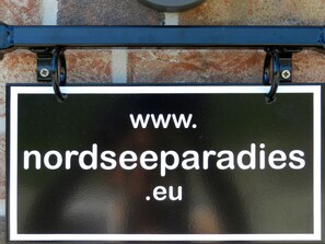 A sign with the text "www.nordeeparadies.eu" mounted on a brick wall. - Holiday Apartment Deck Boat (Butjadingen)