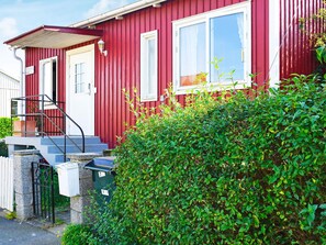 A red building with a white door, a window, and a small porch with steps. - 4 Star Holiday Home in Enskede (Enskede)