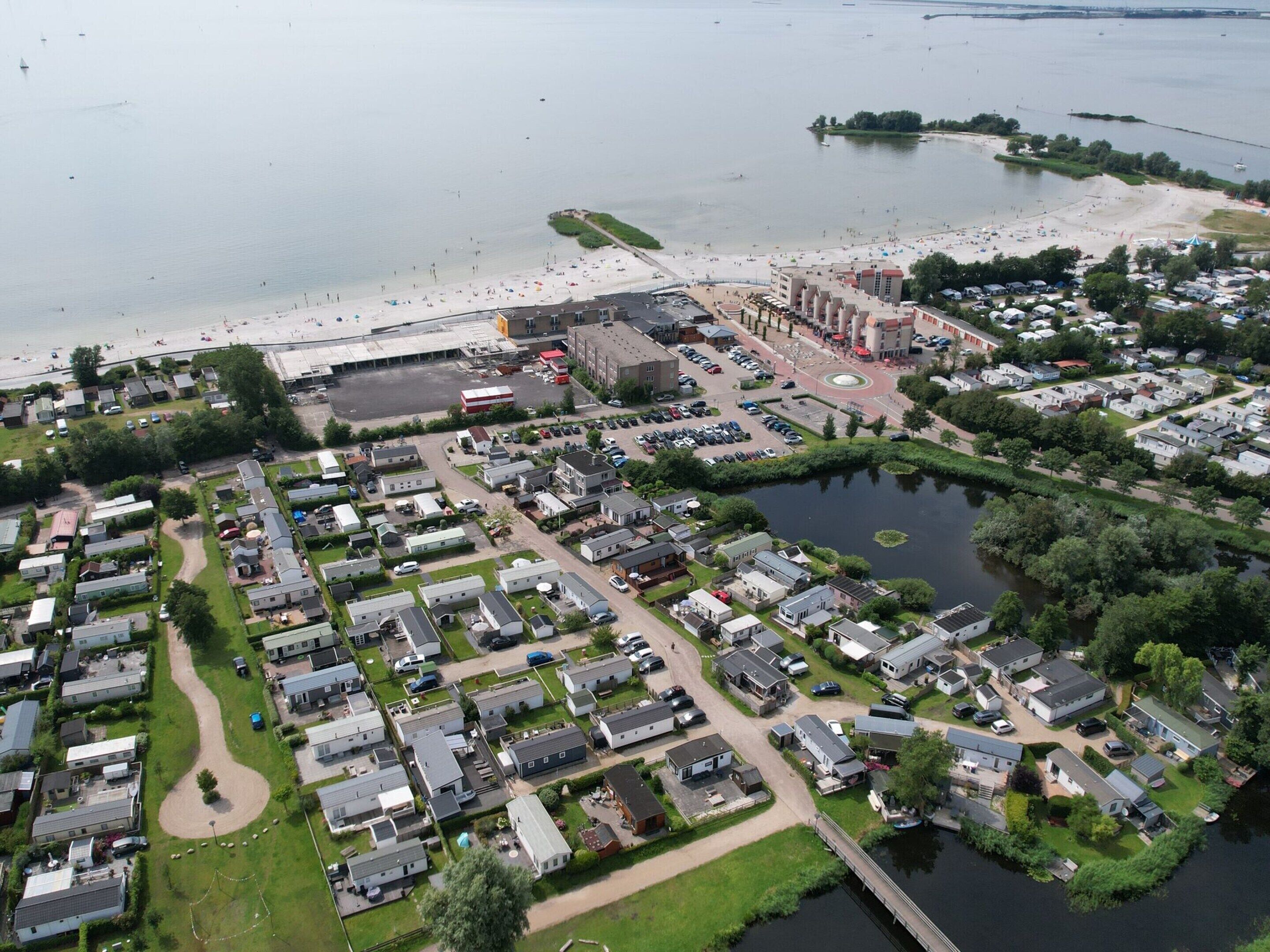 Ilmakuva asuinalueesta, jossa on taloja, ranta ja järvi.