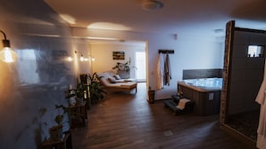 A modern bathroom with a large bathtub, wooden flooring, and a shower area. - Holiday Apartment Swallow's Nest (Eichstetten am Kaiserstuhl)