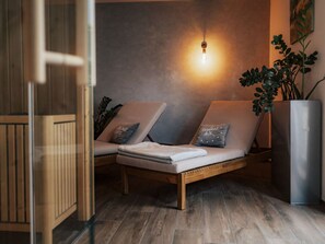 A modern lounge area with two cushioned chairs, a wooden floor, a wall-mounted light, and a potted plant. - Holiday Apartment Swallow's Nest (Eichstetten am Kaiserstuhl)