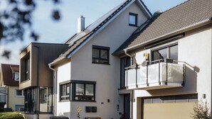 A modern two-story house with a large balcony, a garage, and a well-maintained front yard. - Holiday Apartment Swallow's Nest (Eichstetten am Kaiserstuhl)