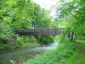 A bridge over a river surrounded by dense greenery.