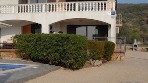 A two-story building with a balcony, a swimming pool, and a stone wall. - Mesmerising Apartment in Punat (Punat)