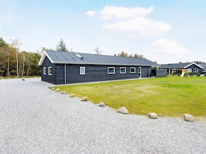 A modern building with a gravel driveway and a grassy lawn. - 5 Star Holiday Home in Albaek (Aalbaek)