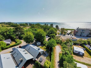 Un quartier résidentiel comprenant un grand immeuble, un parking et une vue sur la mer.