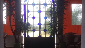 A room with a large window, a dog lying on the floor, and two potted plants. - Holiday Home Between Mountain, Coast (Bollullos Par del Condado)