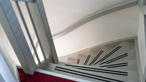 A white staircase with black railings and a red carpet. - Modern Renovated Apartment in the Heart of Sneek (Sneek)