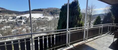 A balcony with a view of a town and a lake.