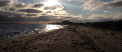A beach with footprints and a clear sky.
