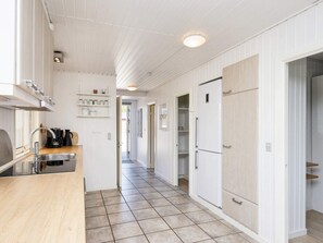 A narrow kitchen with a sink, cabinets, and a refrigerator. - 5 Person Holiday Home in Sydals (Sydals)