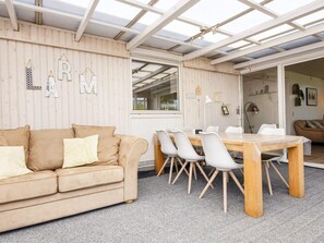 A cozy room with a wooden ceiling, a beige sofa, a dining table with chairs, and a window. - 5 Person Holiday Home in Sydals (Sydals)