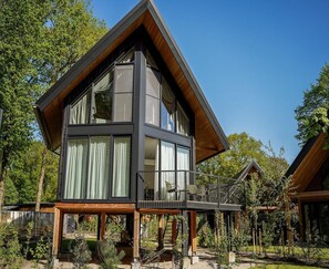 A modern two-story cabin with large windows and a wooden deck. - Spacious Holiday Home With Garden (Wekerom)