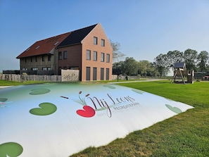 A playground with a mural of a heart and text, a wooden house, and a swing set.