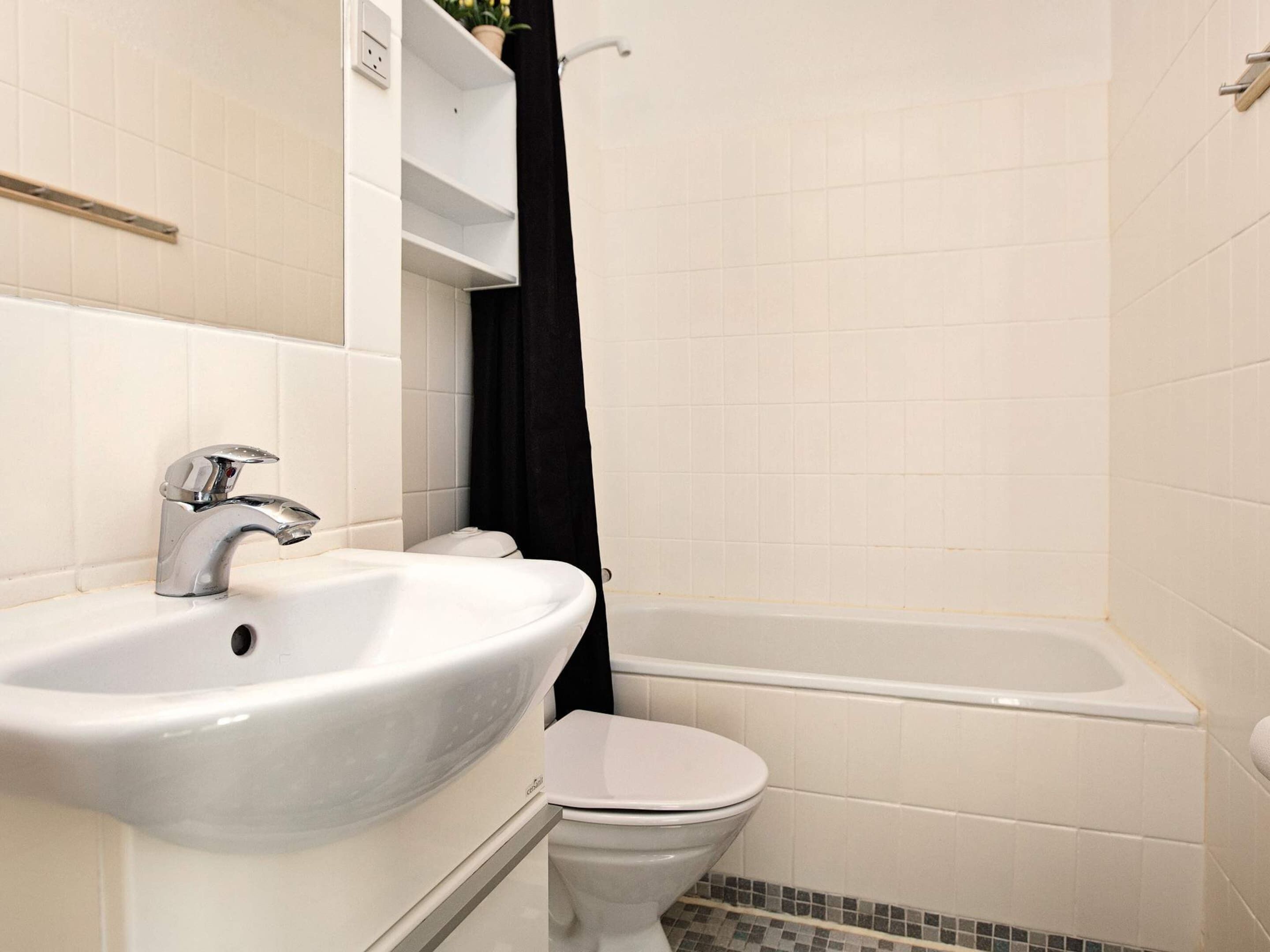 A bathroom with a white sink, a toilet, and a bathtub.
