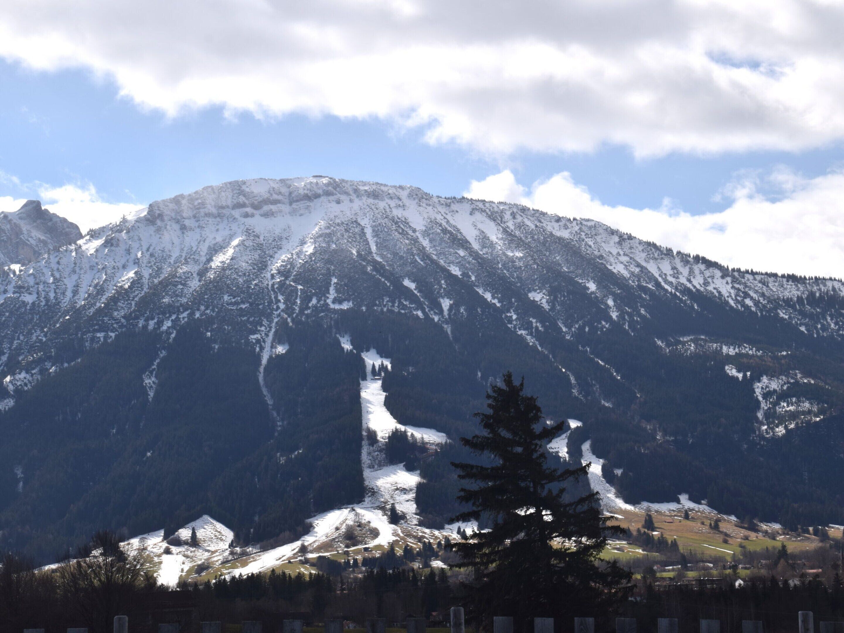 A mountain with snow-covered peaks and a clear sky.