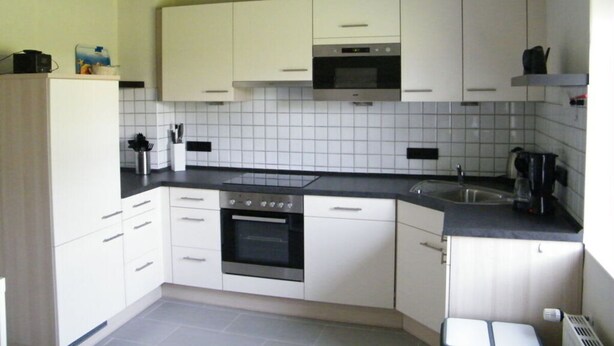 A modern kitchen with white cabinets, a built-in oven, and a microwave. - Muller Comfortable Holiday Residence (Lutzkampen)