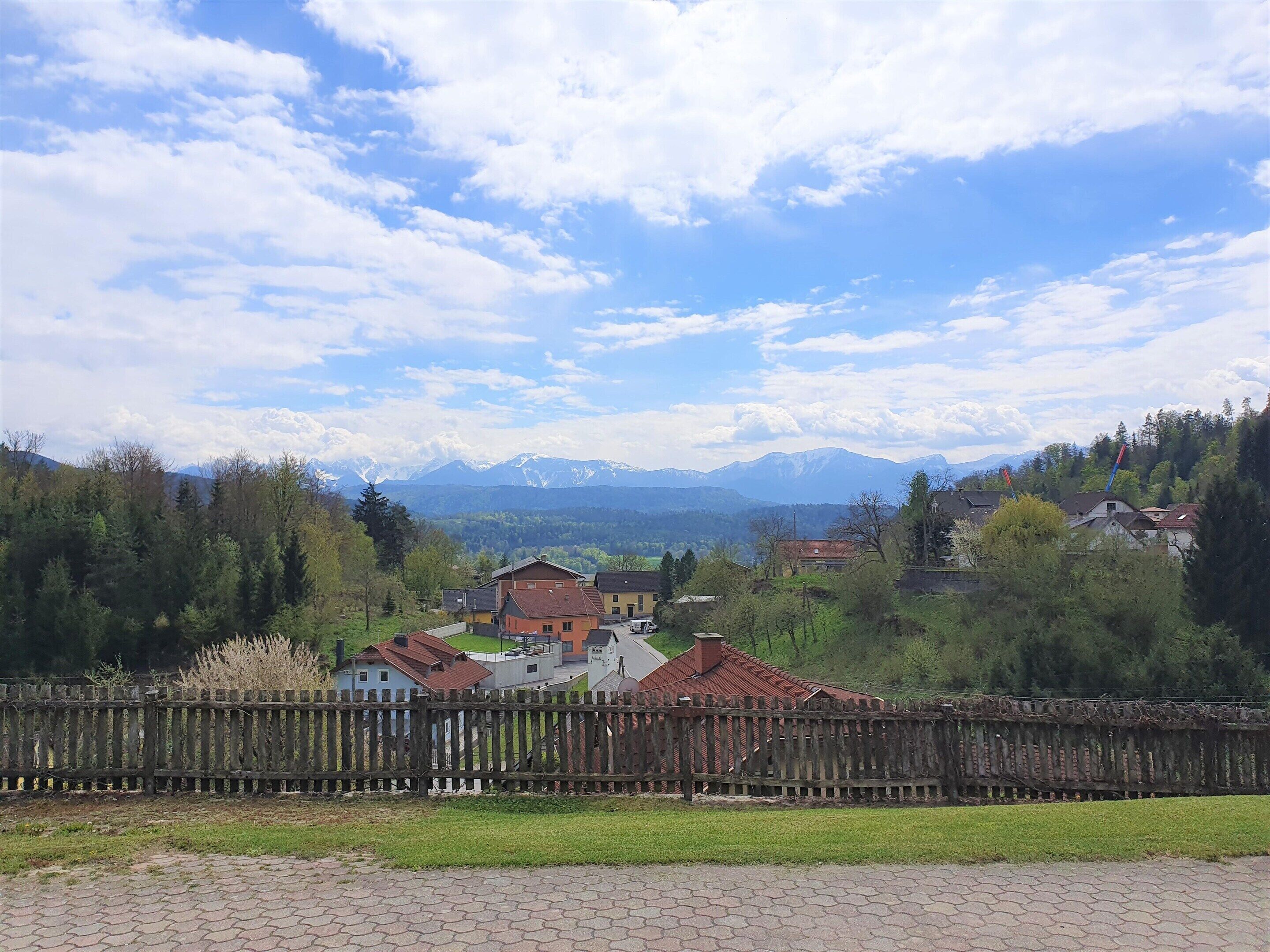 Un quartier résidentiel avec des maisons, une clôture en bois et une chaîne de montagnes en arrière-plan.