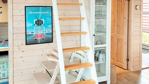 A wooden interior with a white ladder, a glass cabinet with dishes, and a poster on the wall. - 6 Person Holiday Home in Karrebaeksminde (Karrebæksminde)