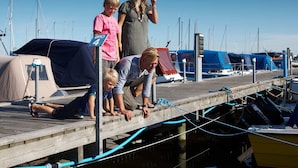 Un muelle de madera con barcos y una tienda de campaña.