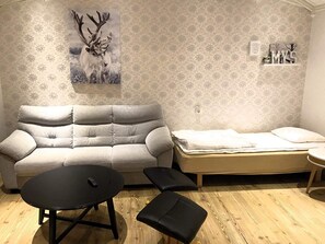A room with a sofa, a small table, a bench, and a bed. - 5 Person Holiday Home in Idre (Idre)