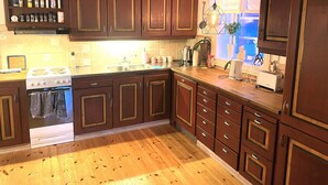 A kitchen with wooden cabinets, a stove, and a window with a view. - 5 Person Holiday Home in Idre (Idre)