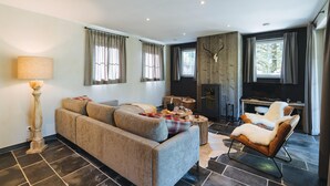 Un salon moderne avec un canapé, un fauteuil et une cheminée.