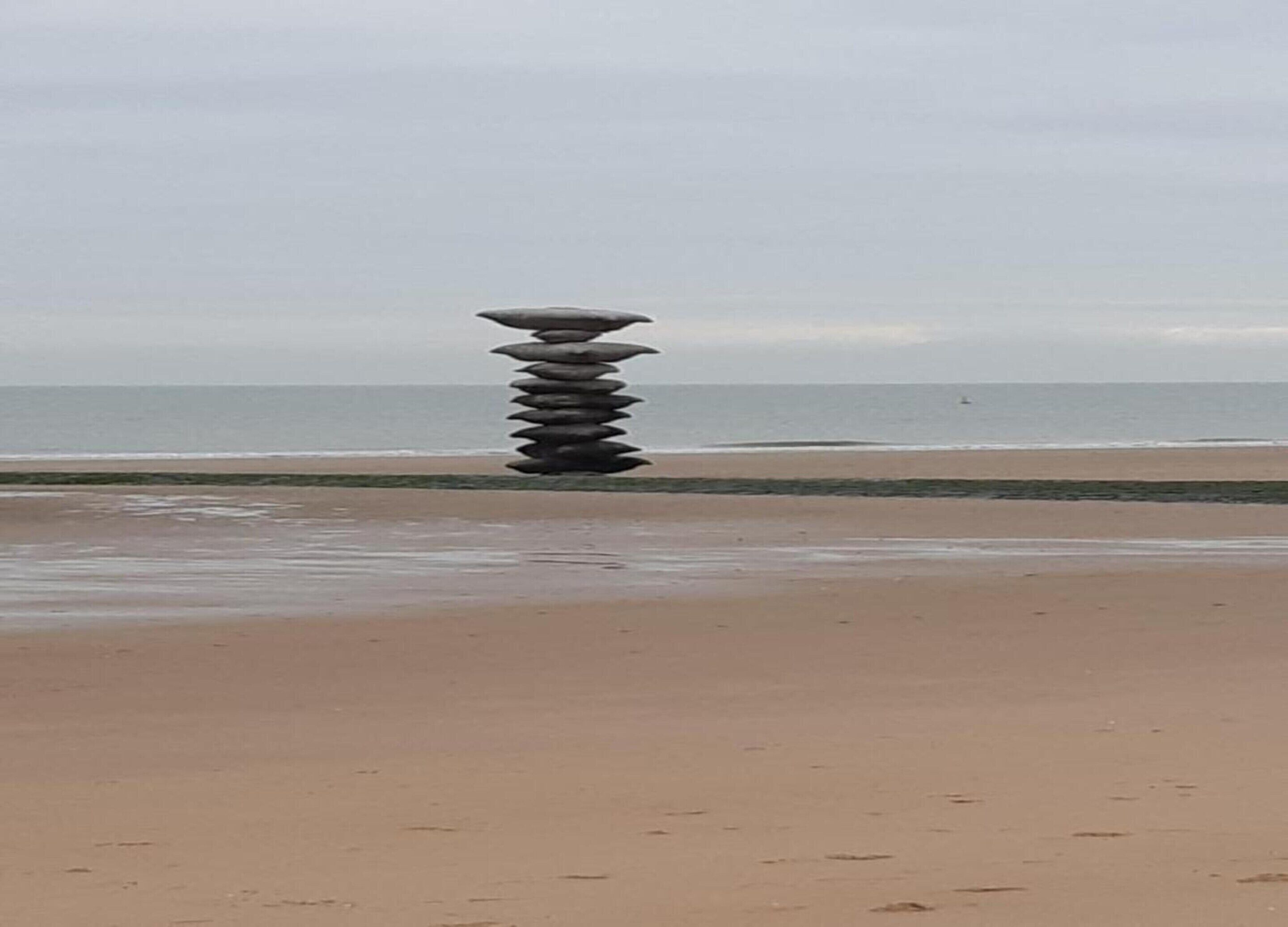 A beach with a stack of stones in the center.