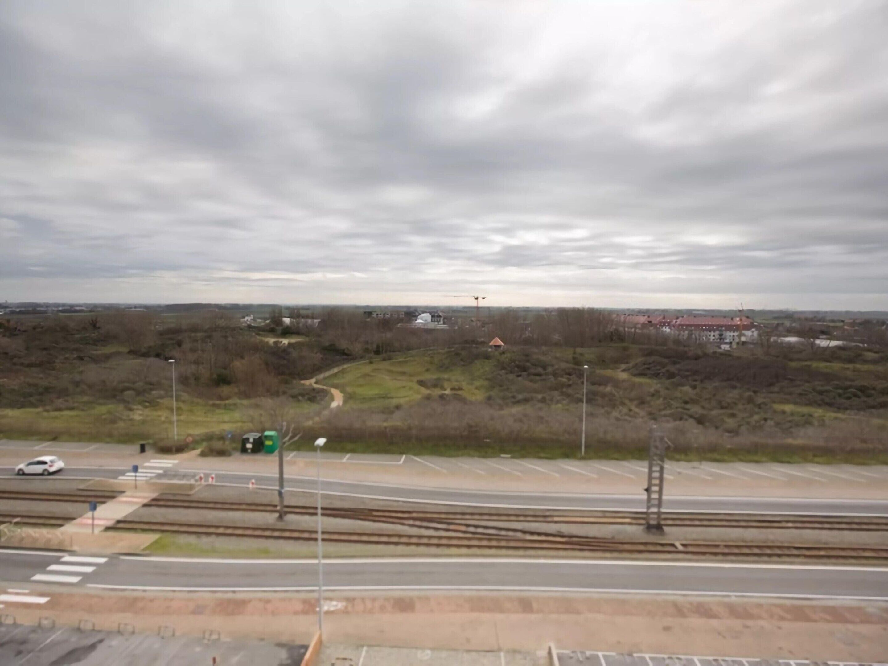 A railway crossing with multiple tracks and a road.