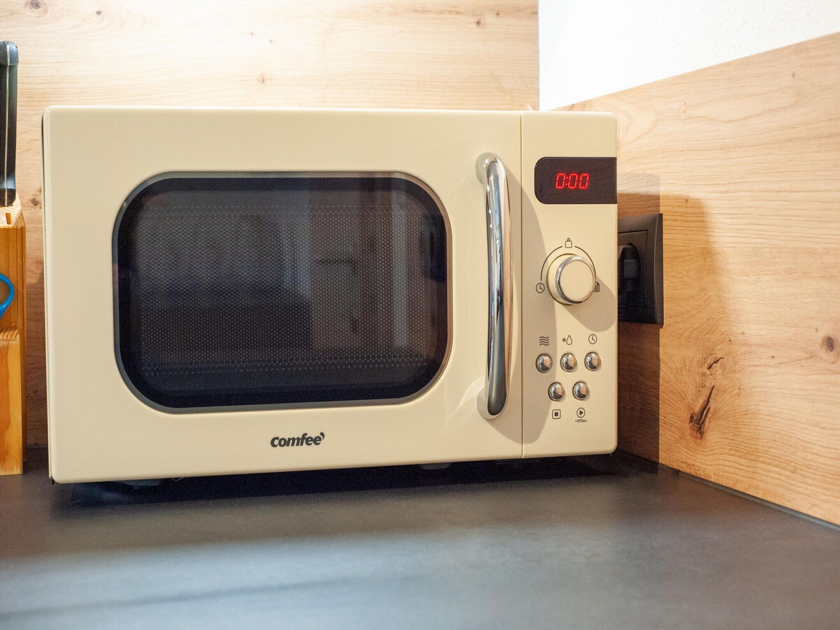 A microwave oven with a digital display, control knobs, and a brand name 'comfee'.