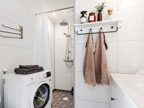 A modern bathroom with a washing machine, a shower, and a towel rack with towels. - 6 Person Holiday Home in Mariefred-by Traum (Mariefred)