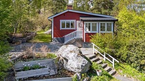 A red cabin with a white porch and steps leading up to a door. - 6 Person Holiday Home in Mariefred-by Traum (Mariefred)