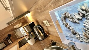 Eine Küche mit Spüle aus Edelstahl, einer Kaffeemaschine, einem Wasserkocher und einem Toaster.
