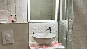 A bathroom with a white sink, a mirror above it, and a shower area with a glass door. - Apartments Jelena - One Bedroom Apartment (Dubrovnik)