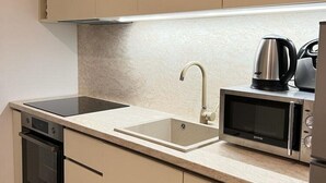 A compact kitchen with a built-in microwave, a kettle, and a dishwasher. - Apartments Jelena - One Bedroom Apartment (Dubrovnik)
