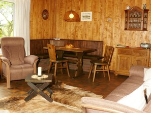 A cozy room with a wooden dining table, chairs, a sofa, and a cabinet. - 1 Siefertshof Comfortable Holiday Residence (Mossautal)