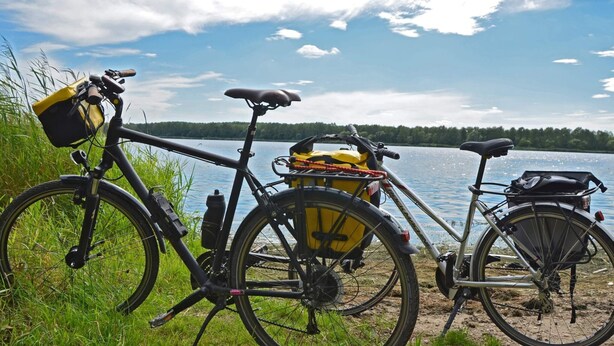 Two bicycles parked by a lakeside with a clear view of the water and trees in the background. - Holiday Home in Lekeryd Near Beach (Lekeryd)
