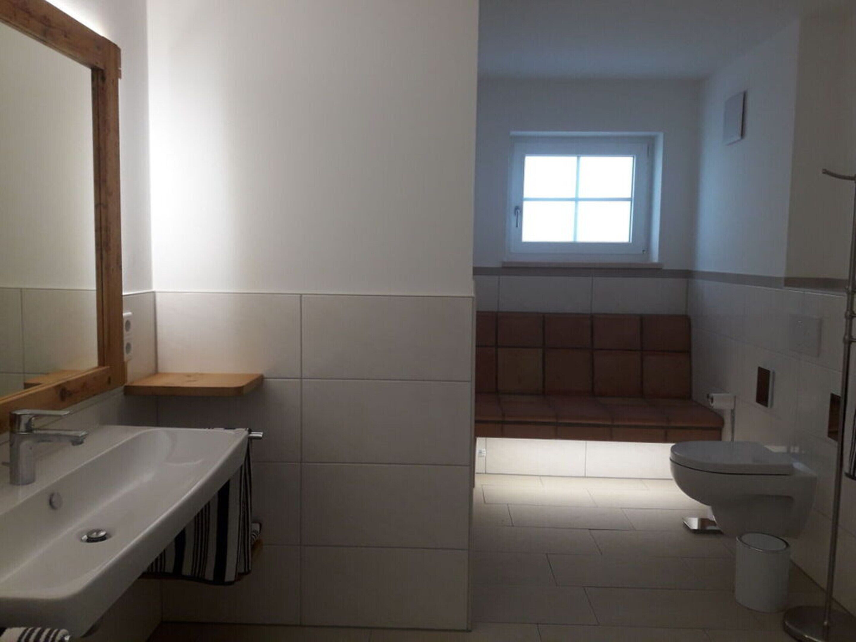 A bathroom with a sink, mirror, and toilet.