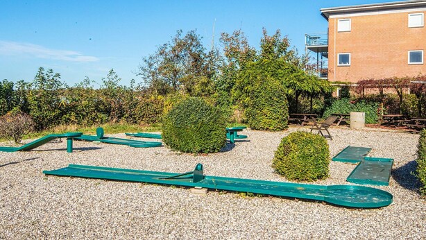 An outdoor area with exercise equipment, a gravel path, and a building in the background. - 4 Person Holiday Park Home in Hejls (Hejls)