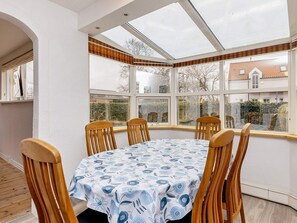 A corner room with a glass enclosure, a round table, and wooden chairs. - 6 Person Holiday Home in Albaek (Aalbaek)