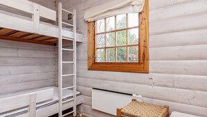 A room with a bunk bed, a ladder, a window with a view of trees, a radiator, and a woven chair. - 6 Person Holiday Home in Vaeggerlose (Vaeggerlose)