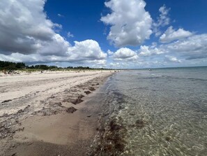 A beach with clear water, sandy shore, and a partly cloudy sky. - 6 Person Holiday Home in Vaeggerlose (Vaeggerlose)