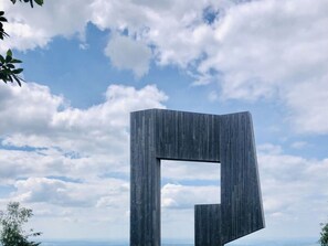 Un edificio moderno y minimalista con un diseño geométrico singular, frente a un cielo parcialmente nublado.