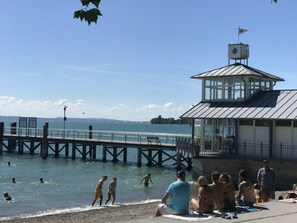 A pier extending into a body of water with people swimming and walking along it. - Holiday Apartment Seagull (Kressbronn)