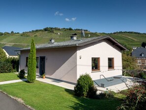 A single-story house with a sloped roof, a small porch, and a well-maintained lawn. - Holiday Home Moselle Valley (Maring-Noviand)